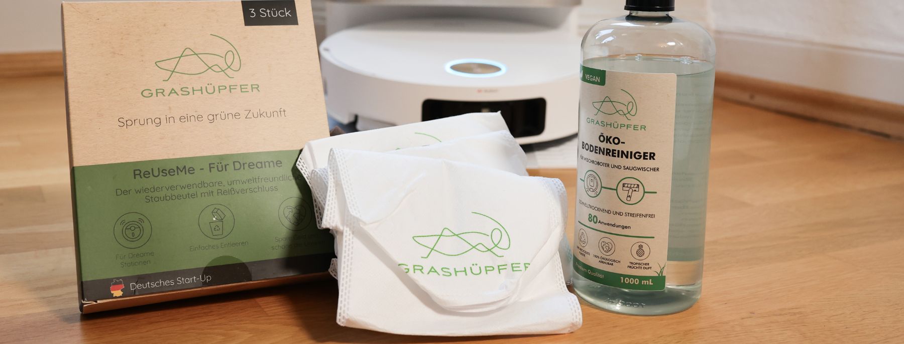 Grashuepfer Staubbeutel Alternative neben Reinigungsmittel und Dreame Saugroboter.