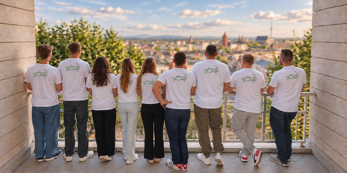 Grashüpfer Team auf einem Balkon mit weißen Shirts und grünem Grashüpfer Logo vor einer Stadtansicht.