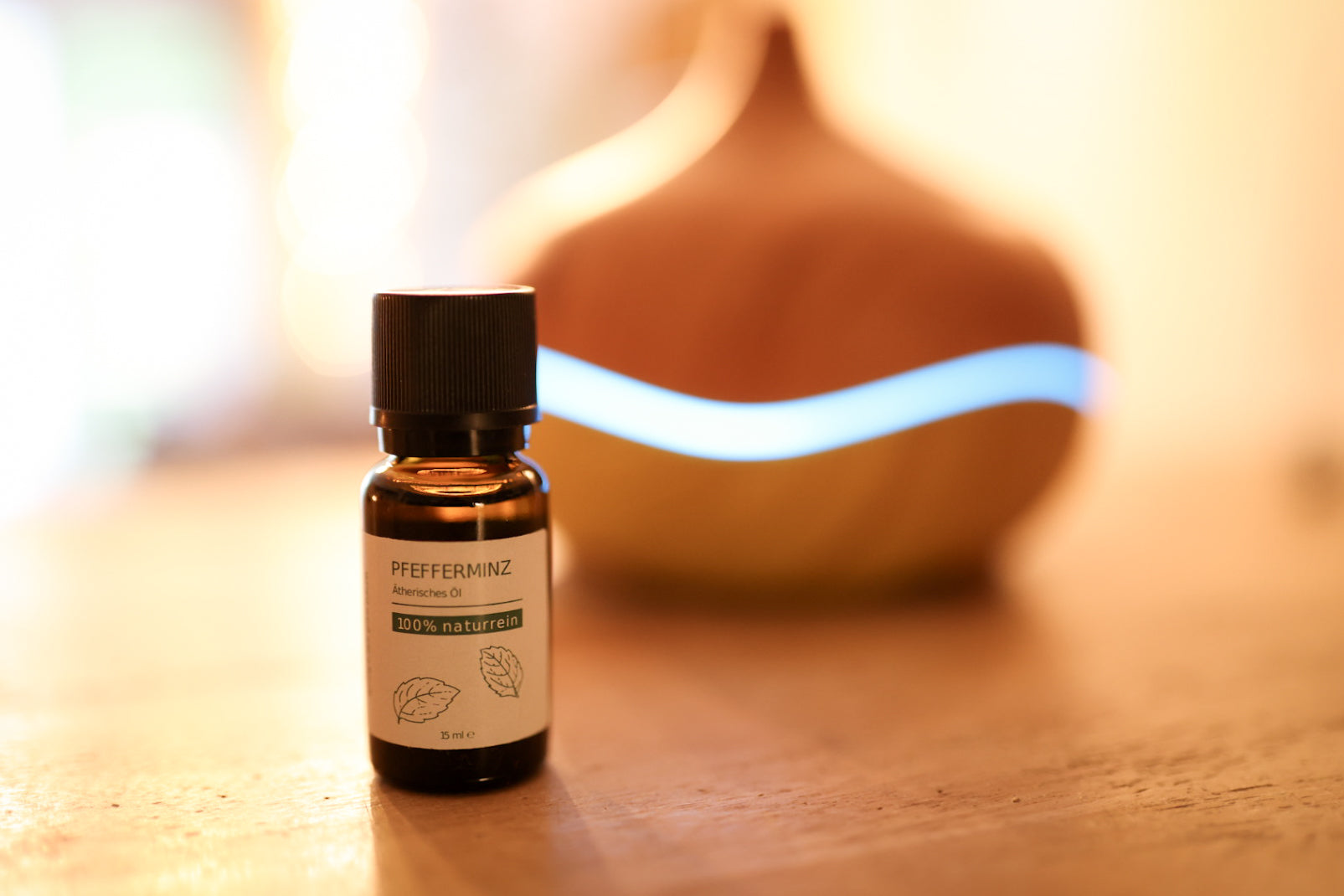 Das 100% naturreine Grashüpfer ätherisches Pfefferminzöl steht vor einem Aroma-Diffuser.