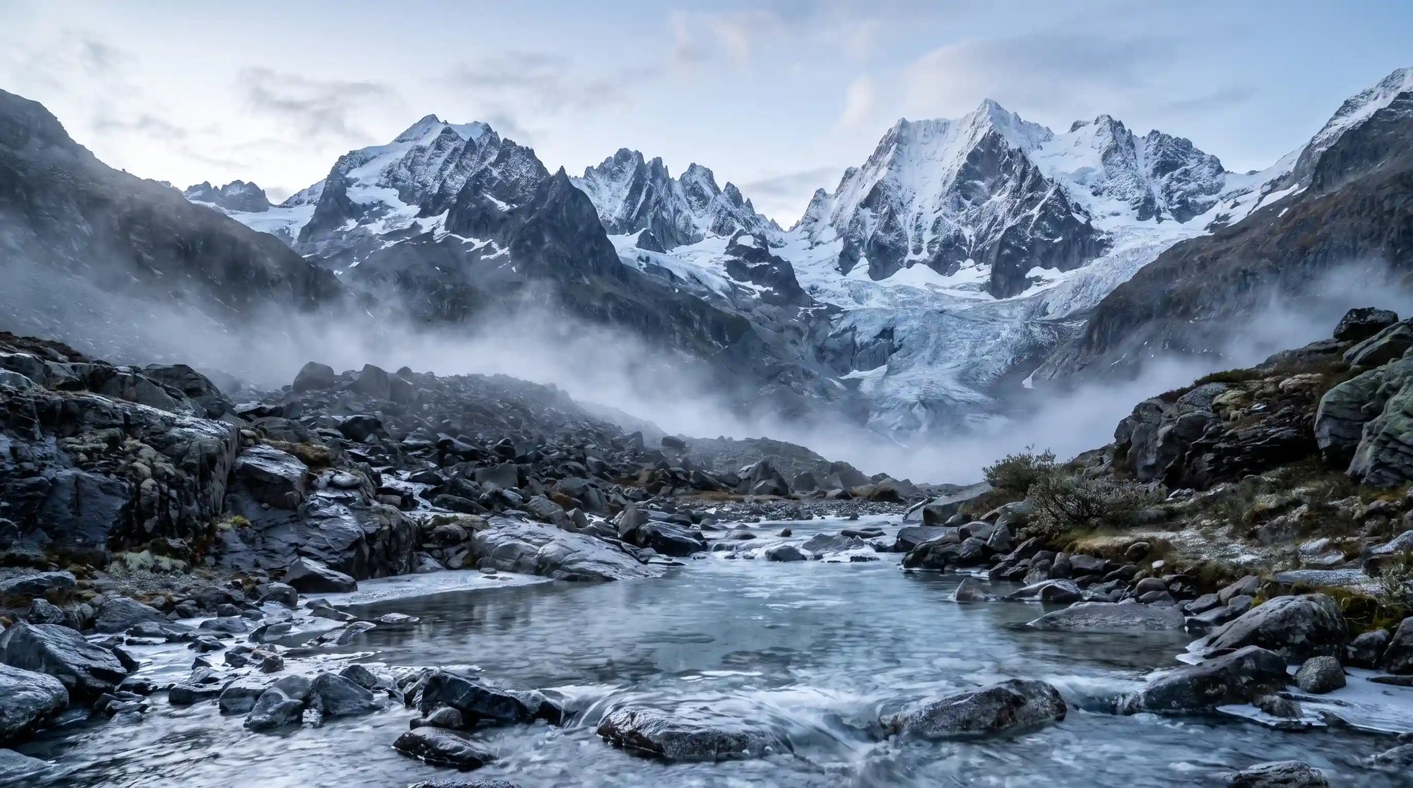 Menthol Duftmotiv mit klarer Bergquelle, felsiger Alpenlandschaft, Nebel und schneebedeckten Gipfeln – passend zum Grashüpfer Öko-Dental-Ultraschallreiniger.