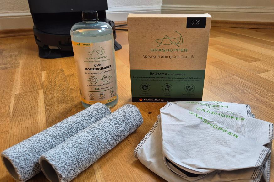Das ECOVACS DEEBOT Mix & Match Set von Grashüpfer ist in Einzelteilen zu sehen, es gibt 2 Wischwalzen, ein Öko-Bodenreiniger für Wischroboter und 3 ReUseMe Staubbeutel für ECOVACS Saugroboter mit Reißverschluss. 