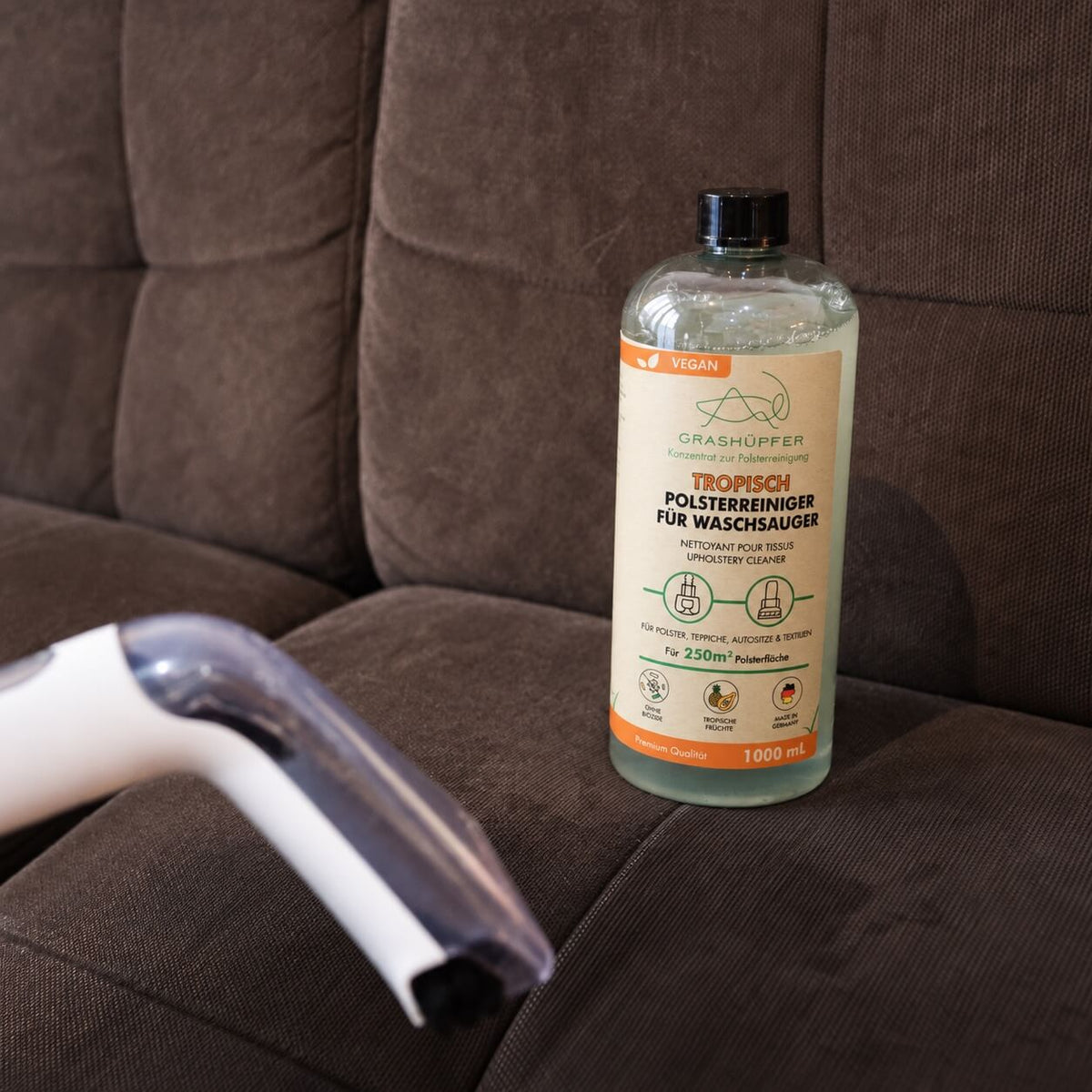 GRASHÜPFER Polsterreiniger für Waschsauger bei der Reinigung eines Stoffsofas mit Polsterdüse.