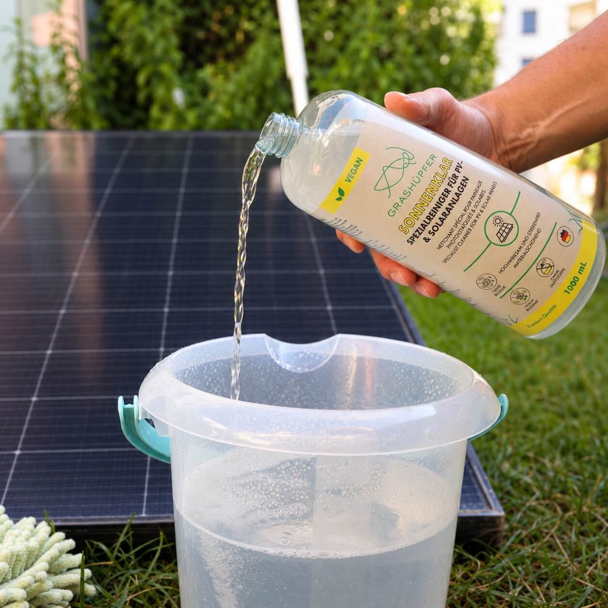 Sonnenklar Solarreiniger von GRASHÜPFER wird für die Reinigung einer PV-Anlage in einen mit Wasser gefüllten Eimer gegeben.
