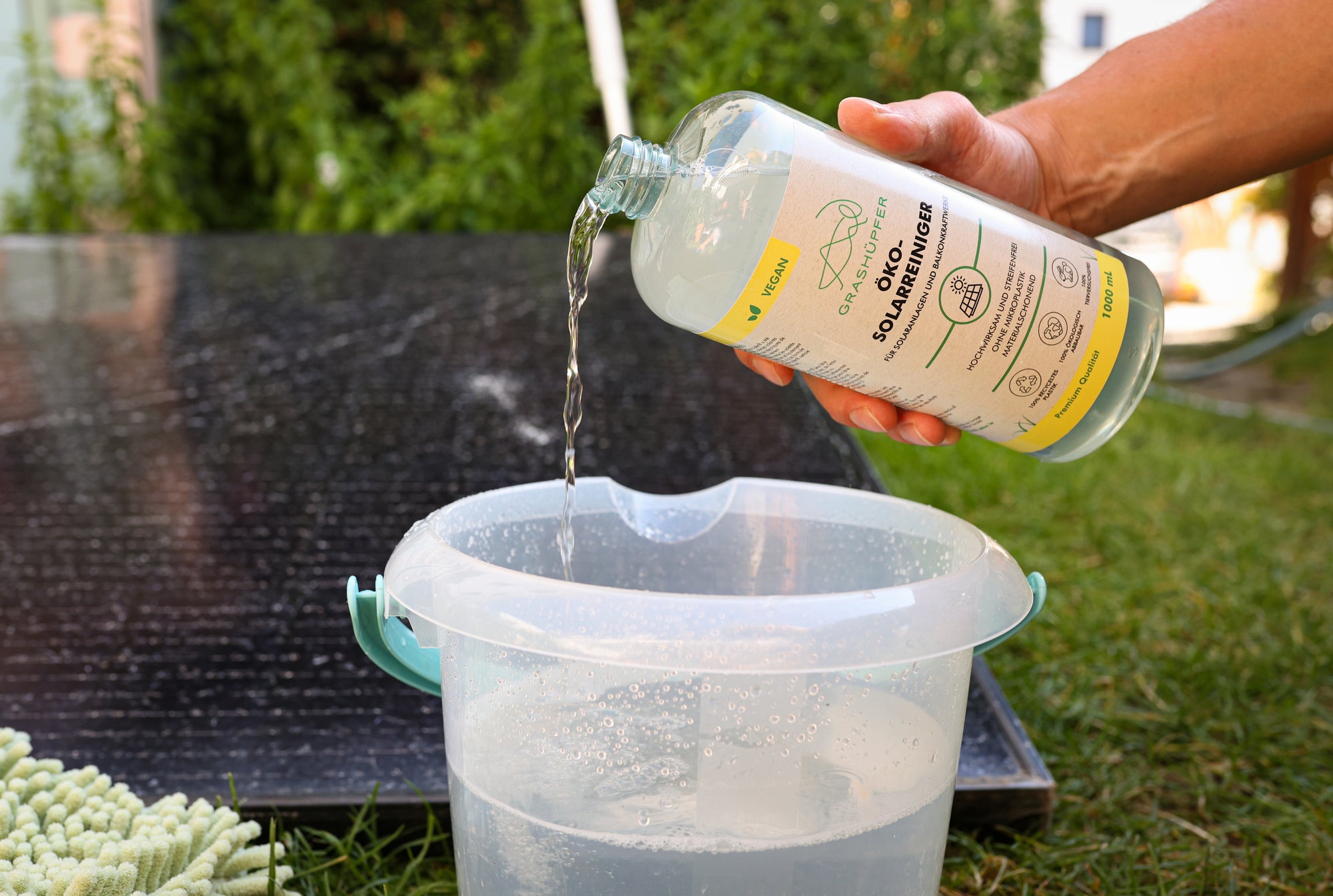 Der Öko-Solarreiniger von Grashüpfer Konzentrat wird in einen Eimer mit Wasser geschüttet, damit das Konzentrat verdünnt wird. Die Dosierung ist durch einen Dosierbecher spielend einfach und dadurch ist das Reinigungskonzentrat sehr ergiebig.